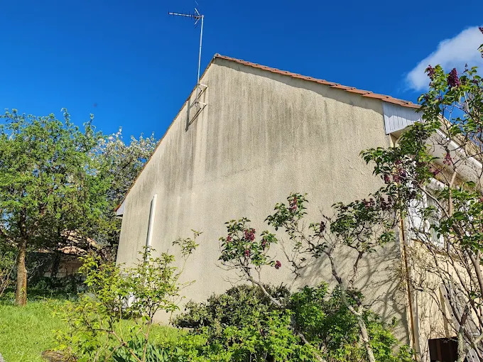 Pignon de maison avec taches d'humidité avant remise en peinture en Haute-Vienne